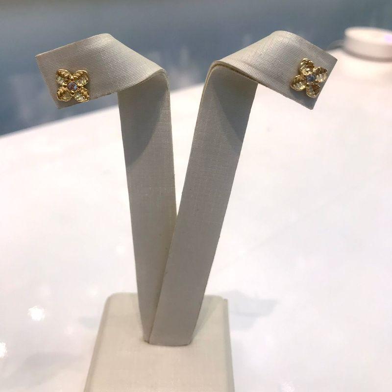 BRINCO MINI FLOR TEXTURIZADA PONTO DE LUZ BANHADO A OURO